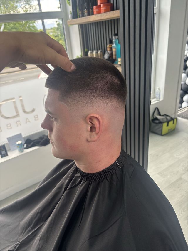 Short buzz cut with a sharp high skin fade